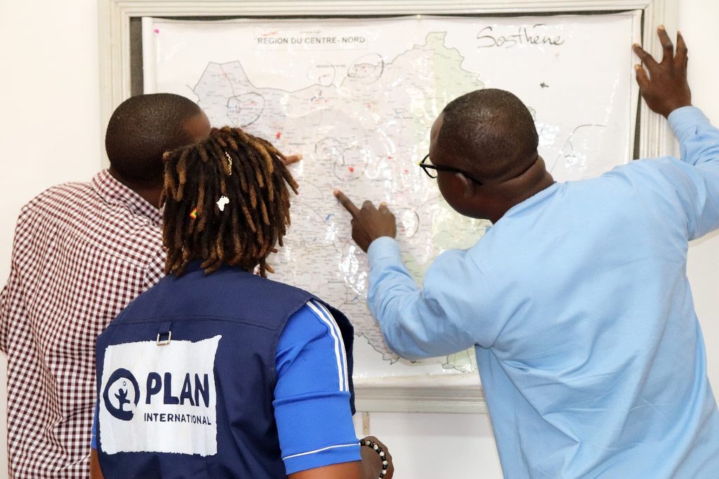 Project supervisor Cherifatou looks at map of Centre-North region with emergency team members. 