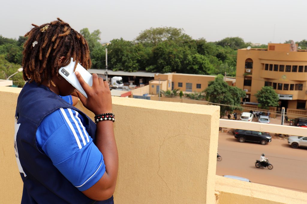 Cherifatou speaks on her mobile phone with a project participant.