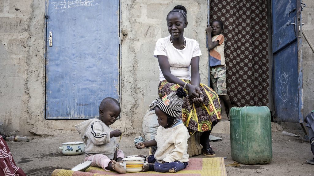Bandiba watches her younger children have their breakfast in front of their house in Fada N'Gourma, eastern Burkina Faso. 