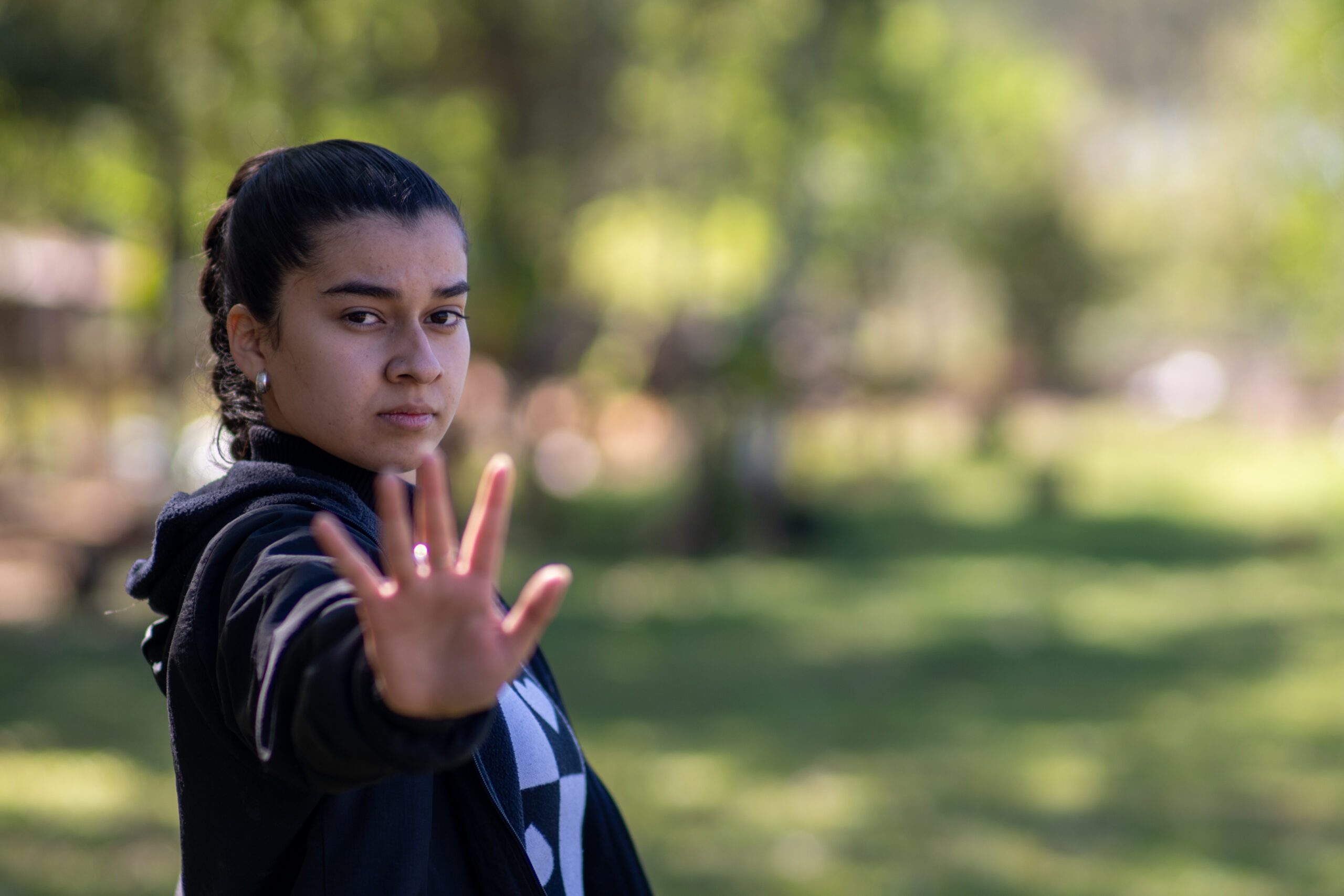 Niña mano en alto fondo verde