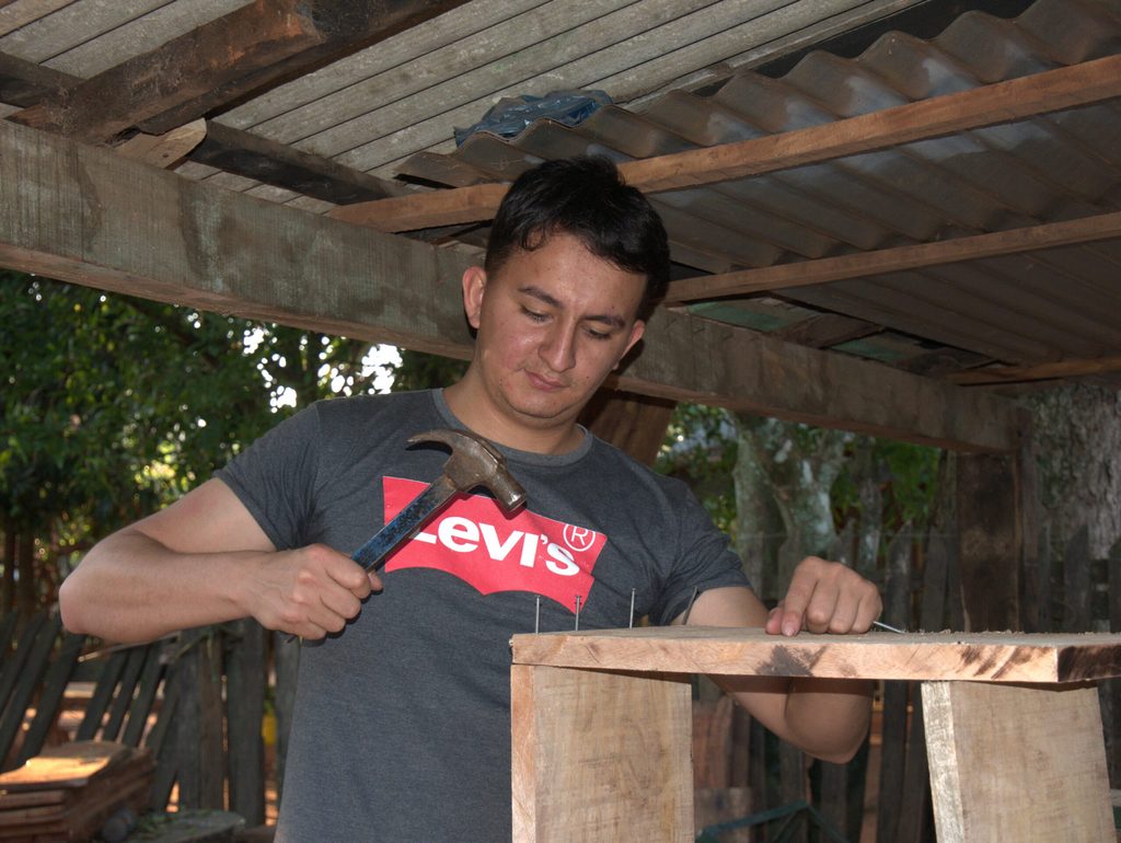 Delio banging nails into bee-keeping box.