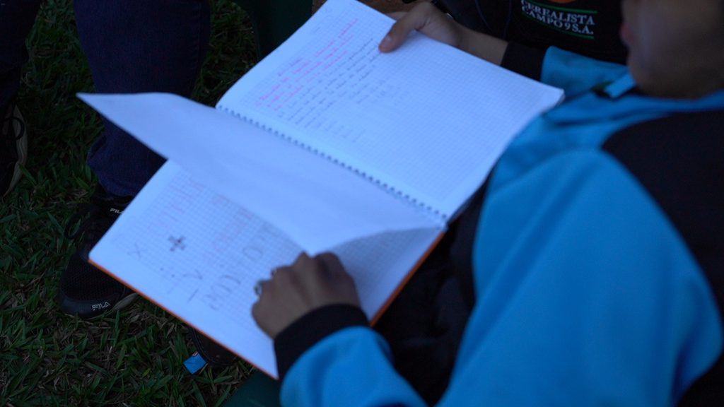 Milagros looking in her school notebook. 