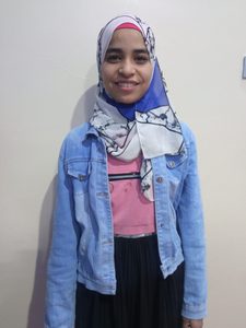 Ibtessam standing and smiling.