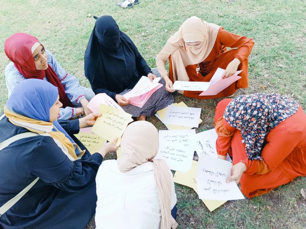 Young women are taking part in an activity and are writing on cards.