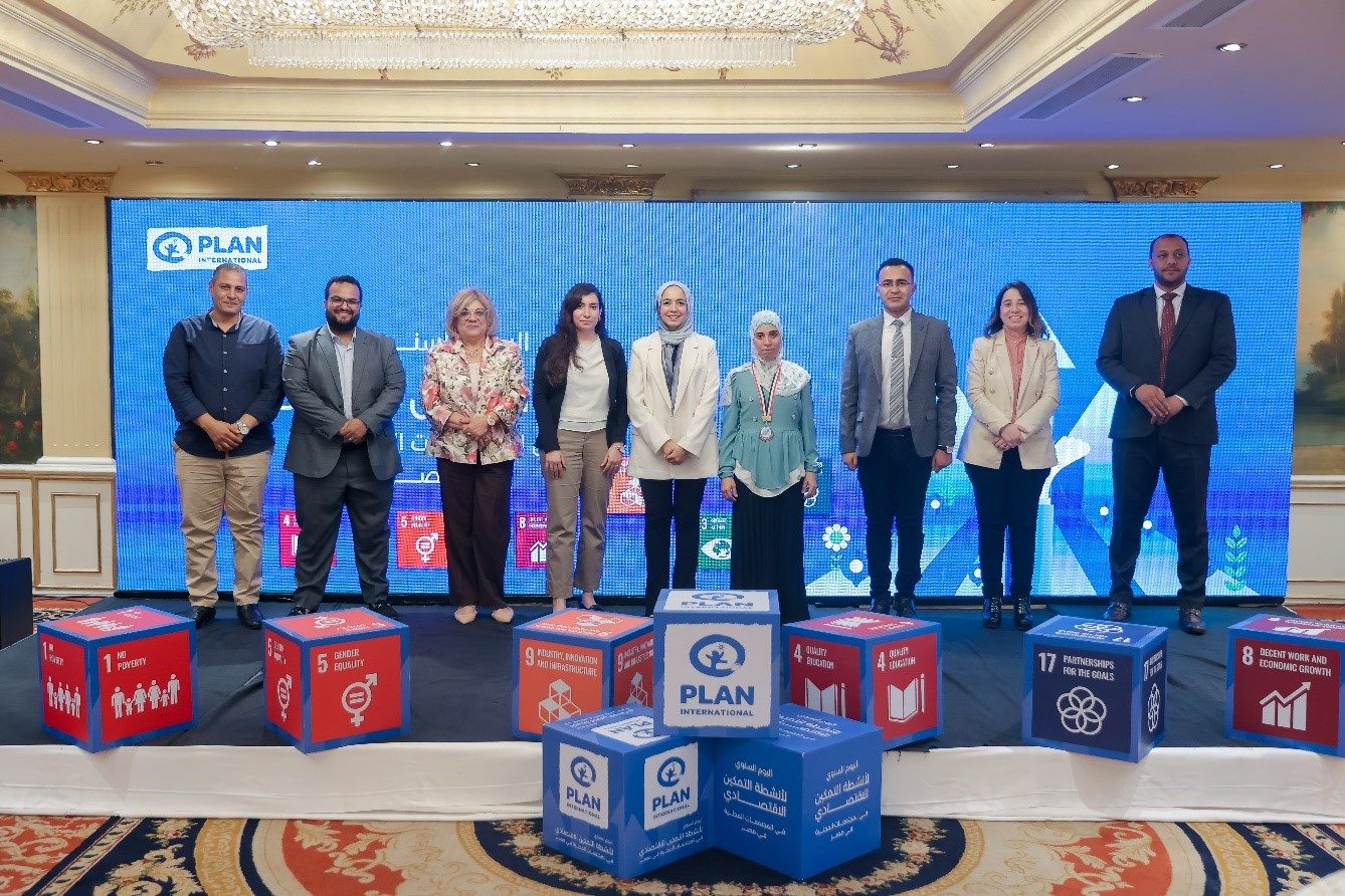 Hala, in green, in a group photo during the annual showcase event for economic interventions in local communities 