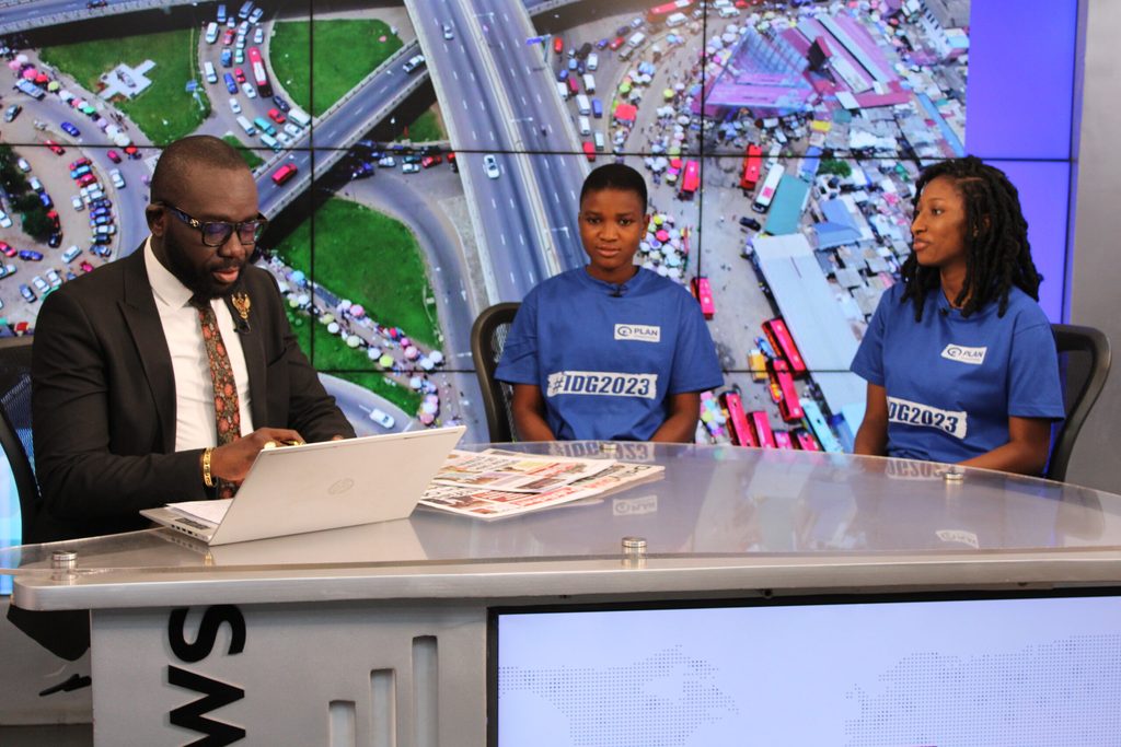 A male TV presenter sitting at a news desk with Linda and Mary. 