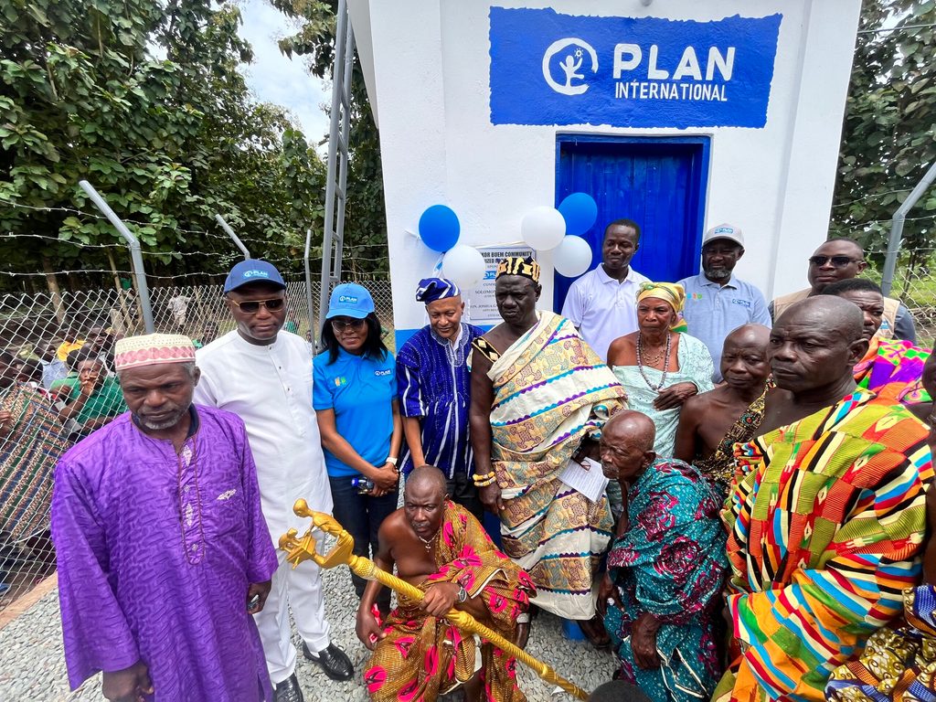 Chief and elders of the community pose with staff of Plan International Ghana in front of the mechanised water system.