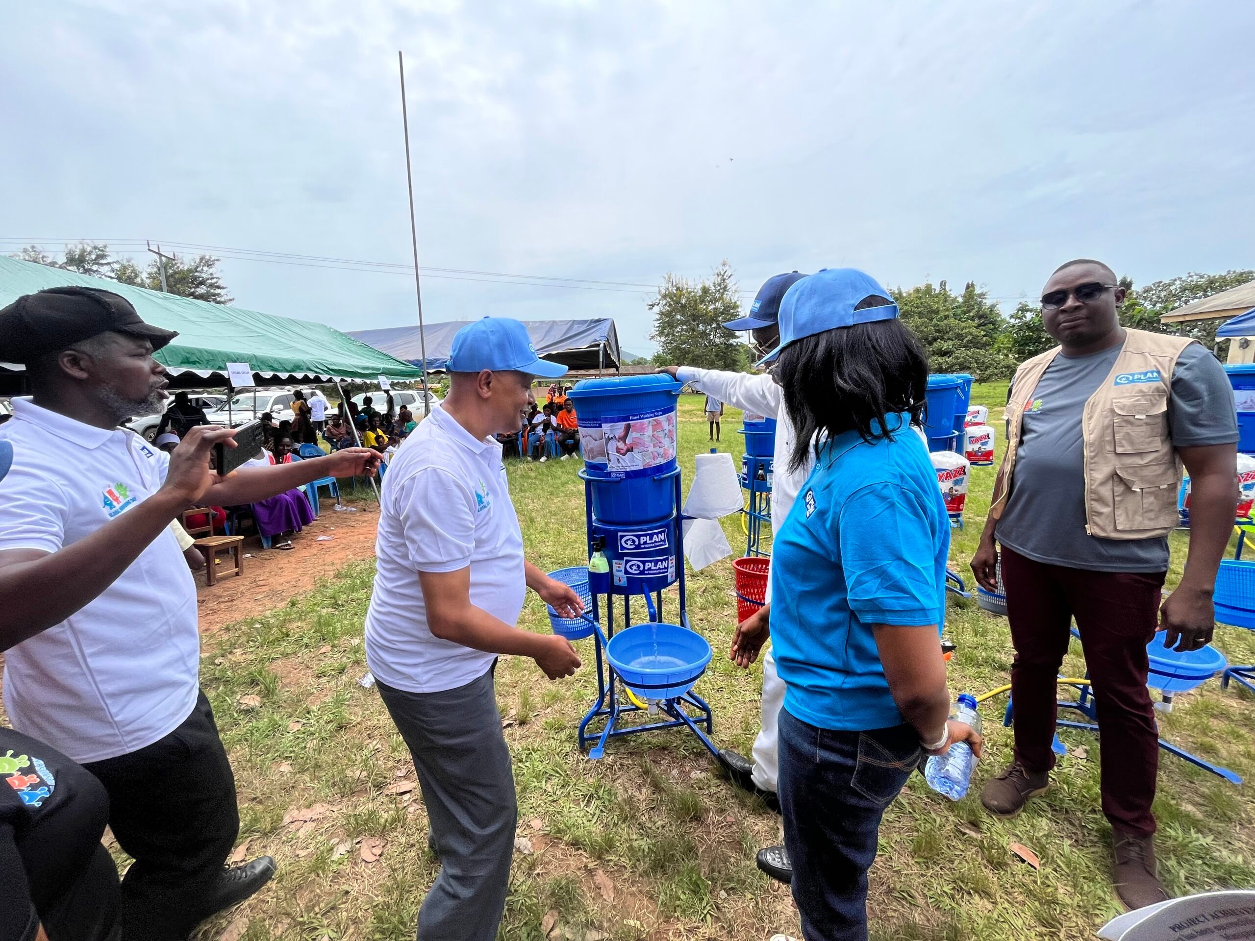 Country director handing over donated items to the MCE of Jasikan and the community.