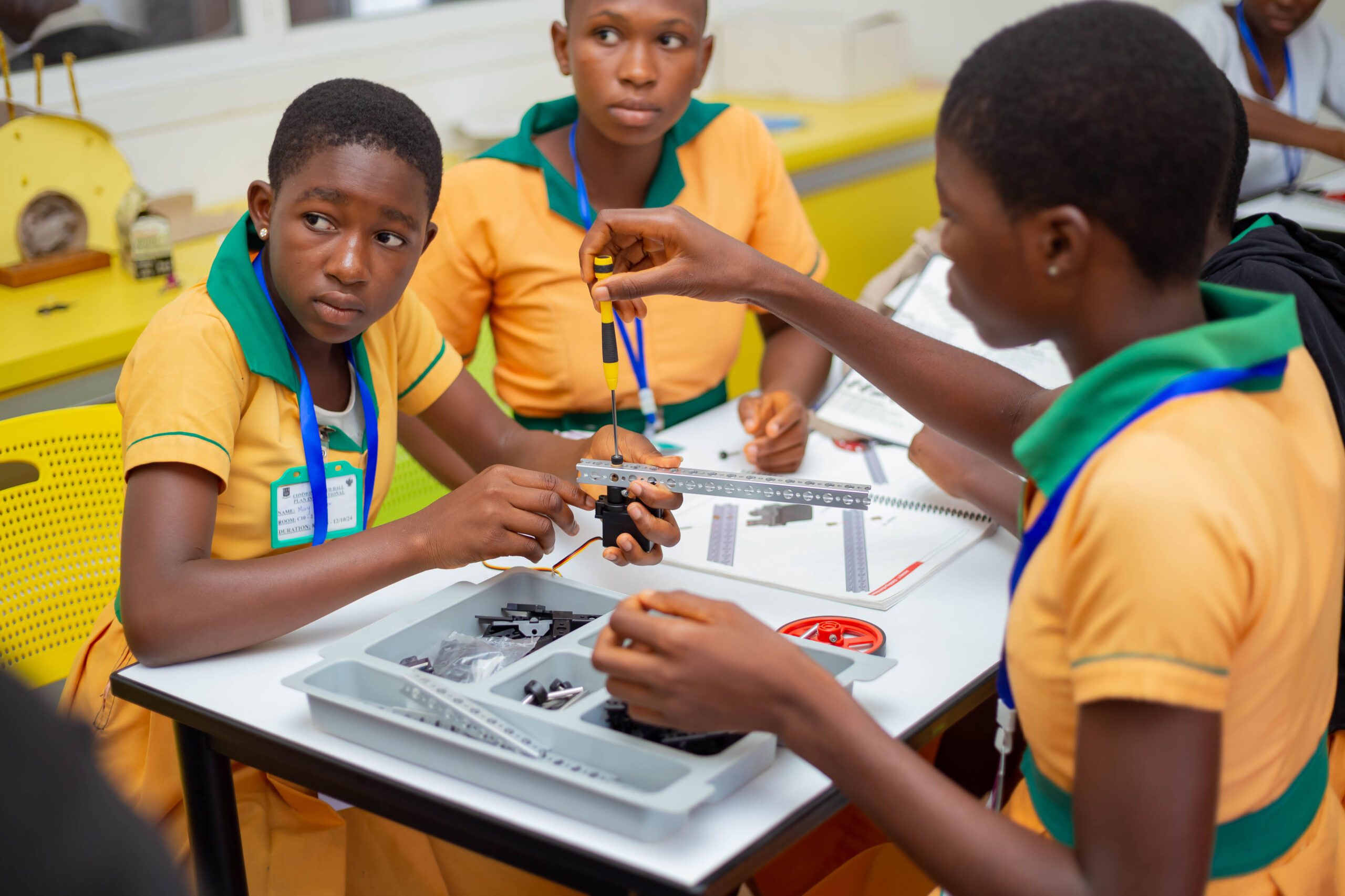 3 girls are building a robot. 