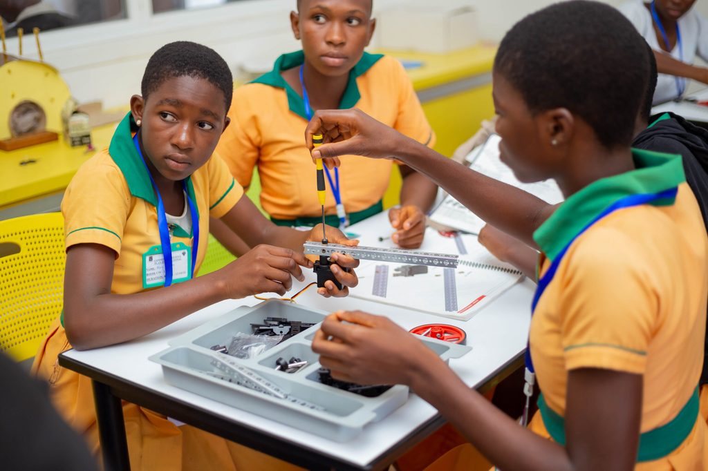3 girls are building a robot.