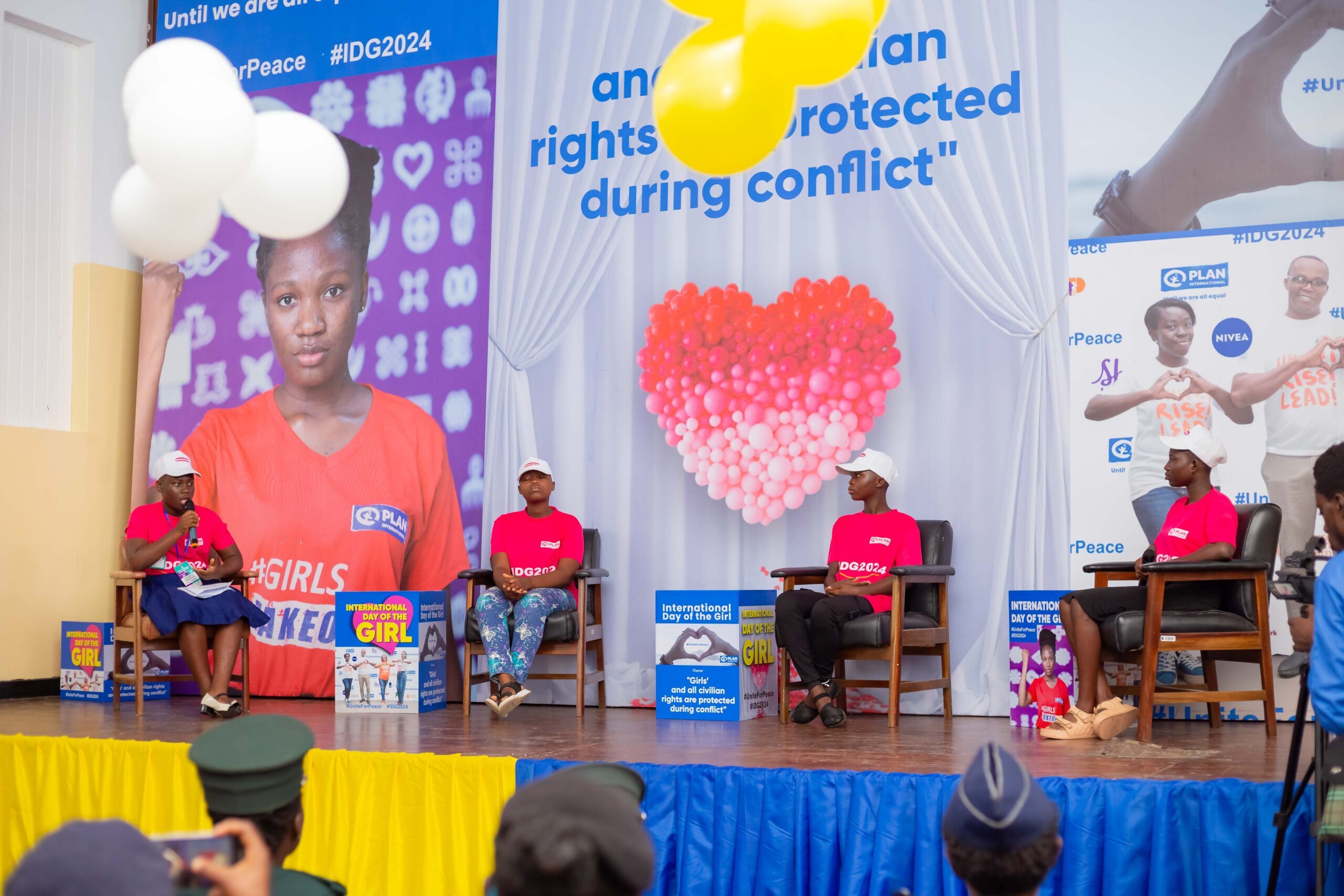 Young people speak on stage. 