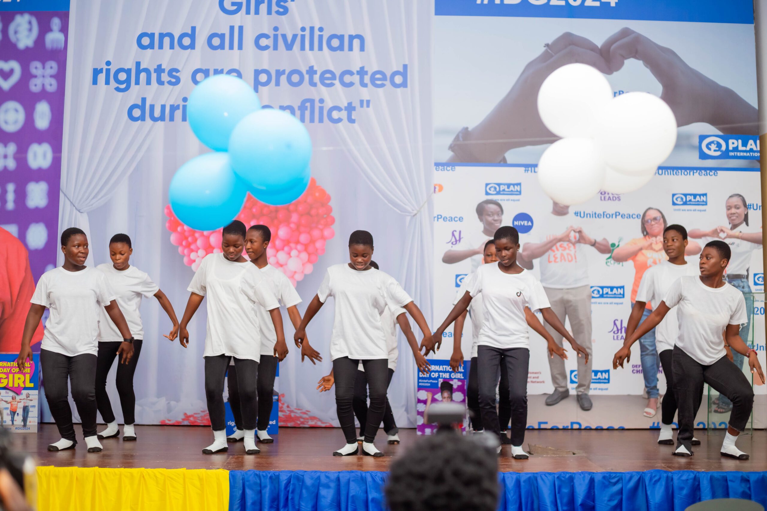 A young dance group perform on stage. 