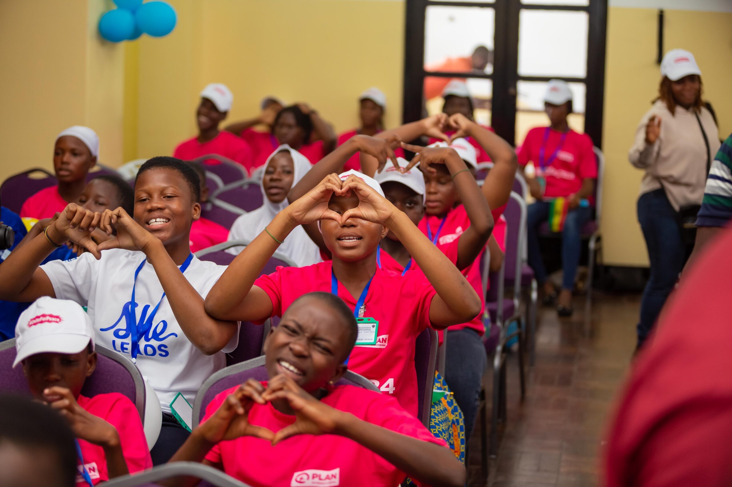 Young children showing the symbol of Unite for Peace.