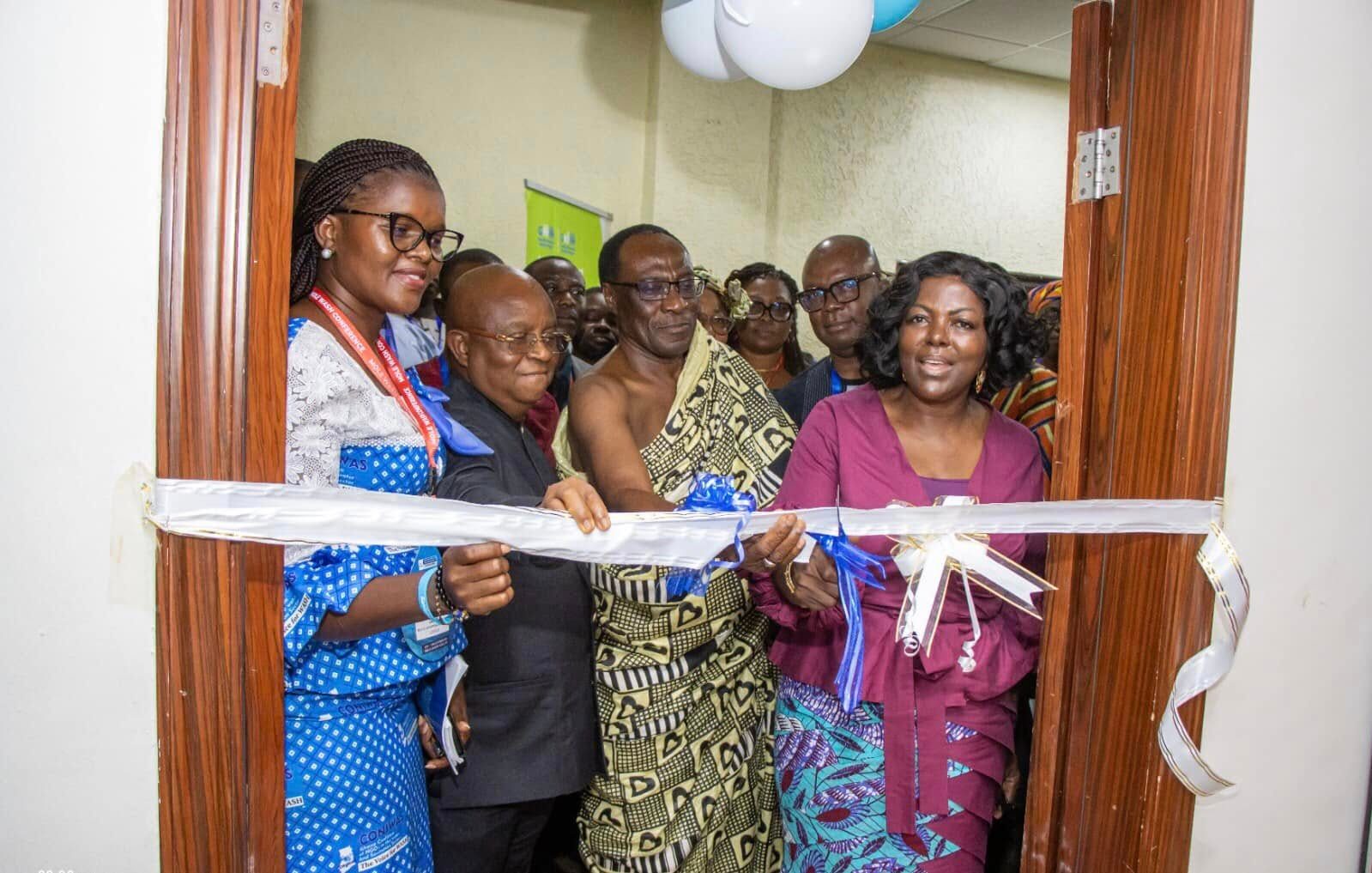 Some people gather to cut a ribbon. 