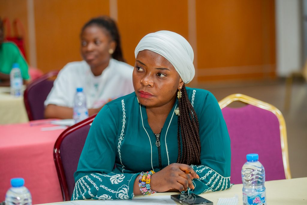 Alberta sitting and listening during a woman's programme.