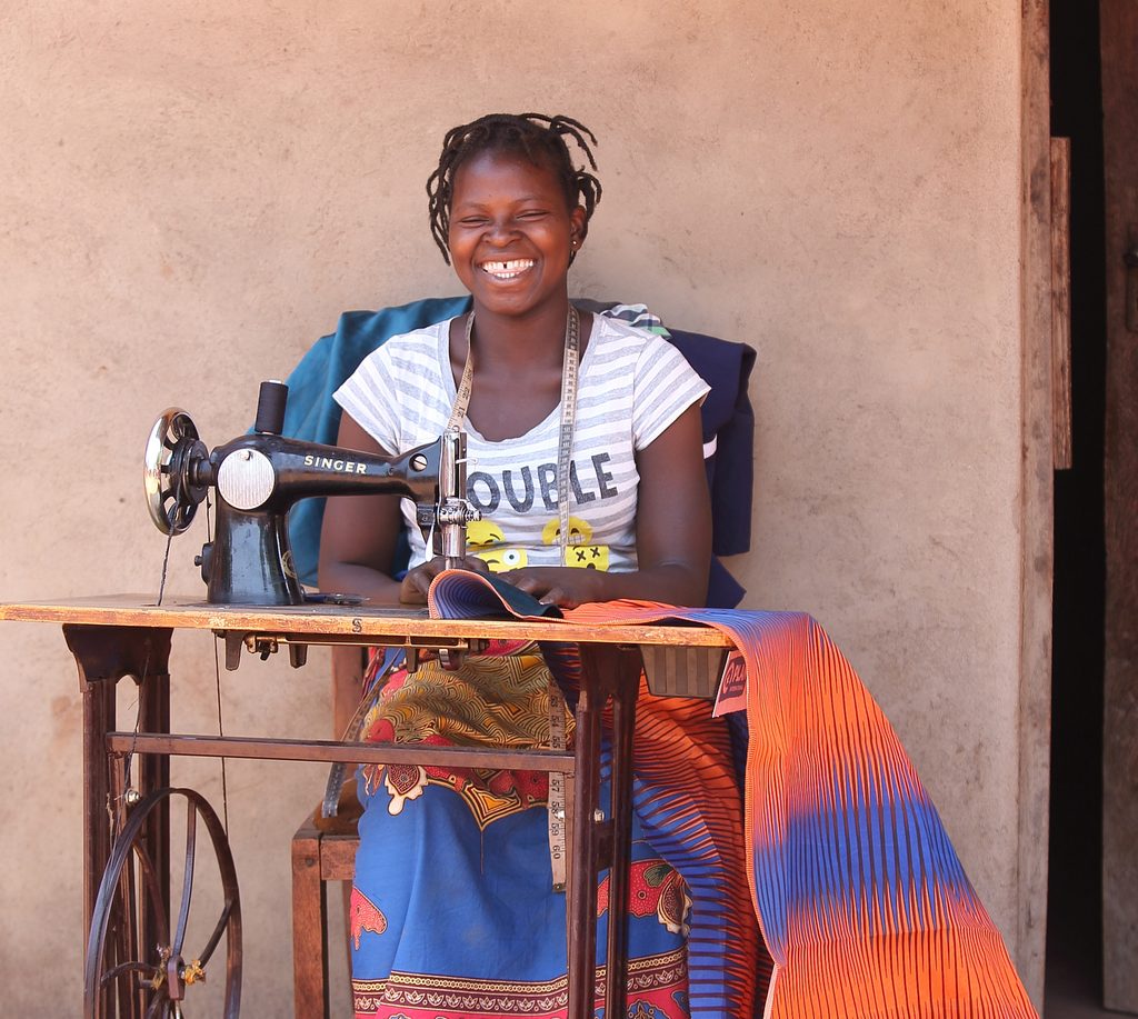 Eliza sitting at her sewing machine.