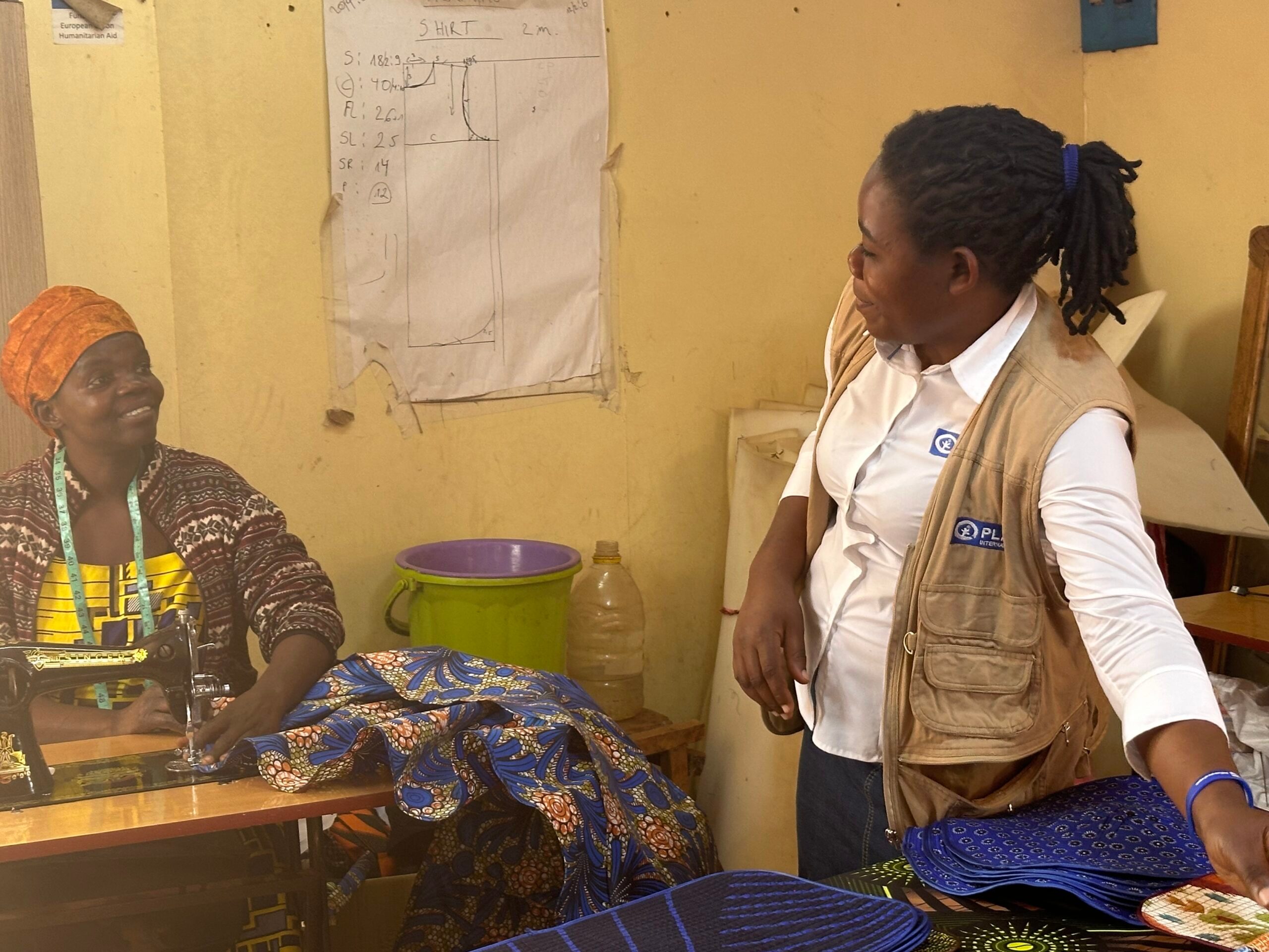 A tailor at Dzaleka Refugee Camp having a word with Bridget. Photo by Winnie Botha-Plan Malawi