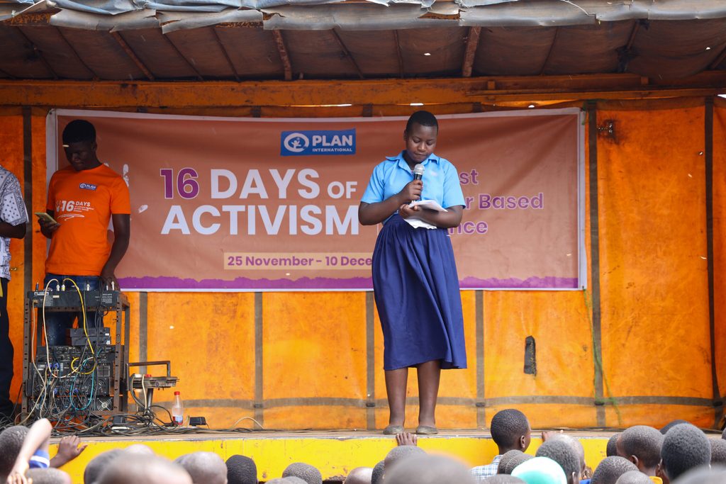 A girl reads a poem on stage.