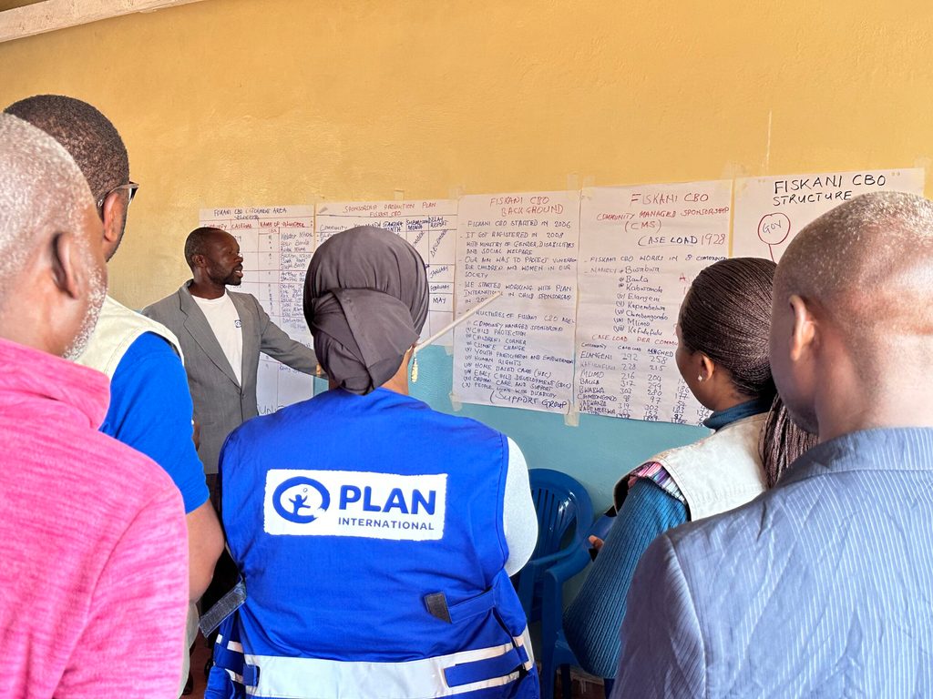 Bexton explaining to Plan Malawi Leadership Team how he documents sponsored children Bexton engaging with the Plan Malawi Leadership Team