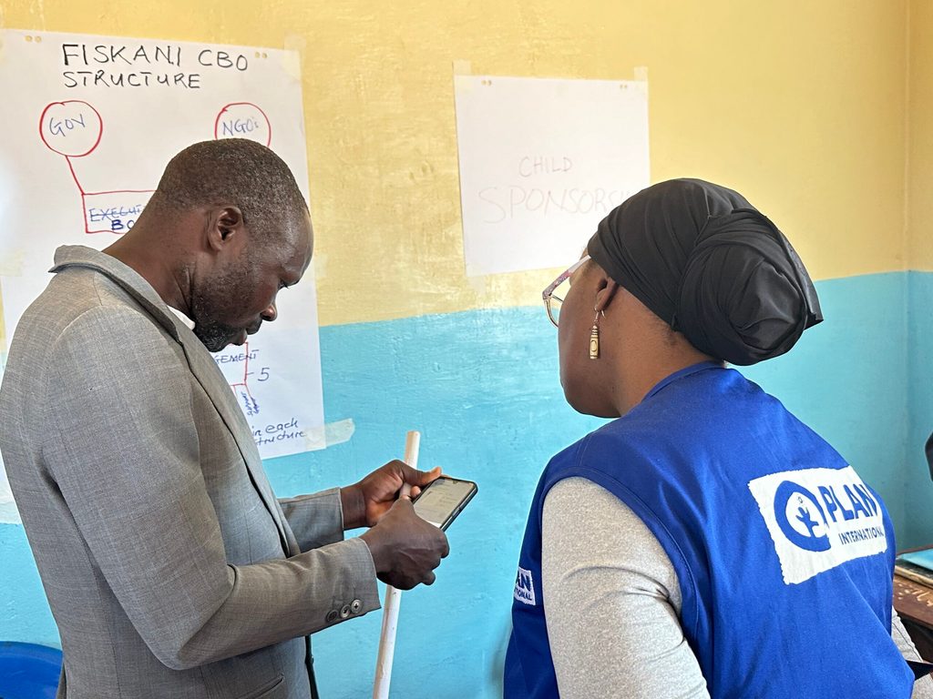 Bexton explaining to the Country Director how he works as a sponsorship photographer Bexton interacting with Mwape Mulumbi, Country Director-Plan Malawi