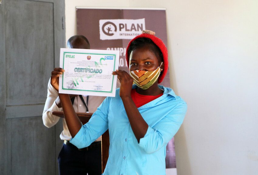 Girl showing off her graduation certificate from a Plan International skills programme