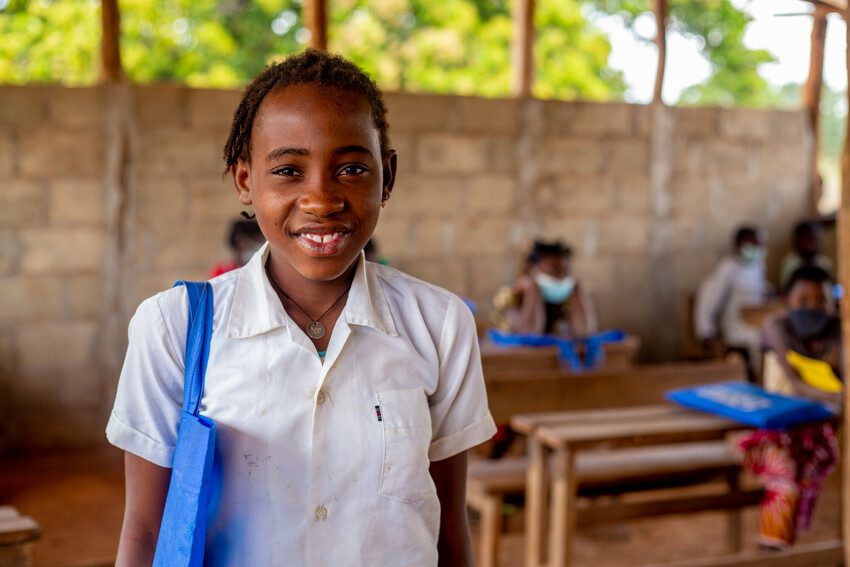 Amina, 11, with her school kit provided by Plan International