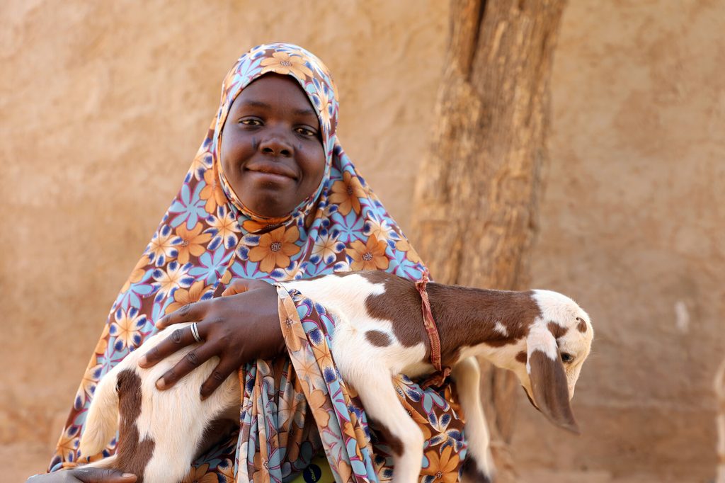 Aichatou proudly holding a young goat.