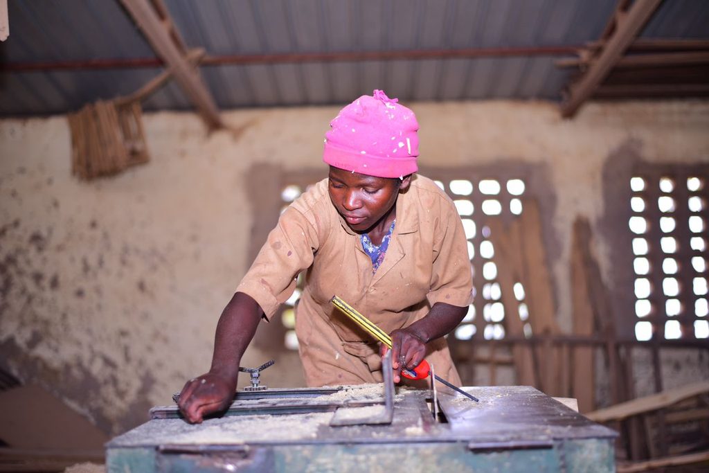 Claudine working at the carpentry desk,