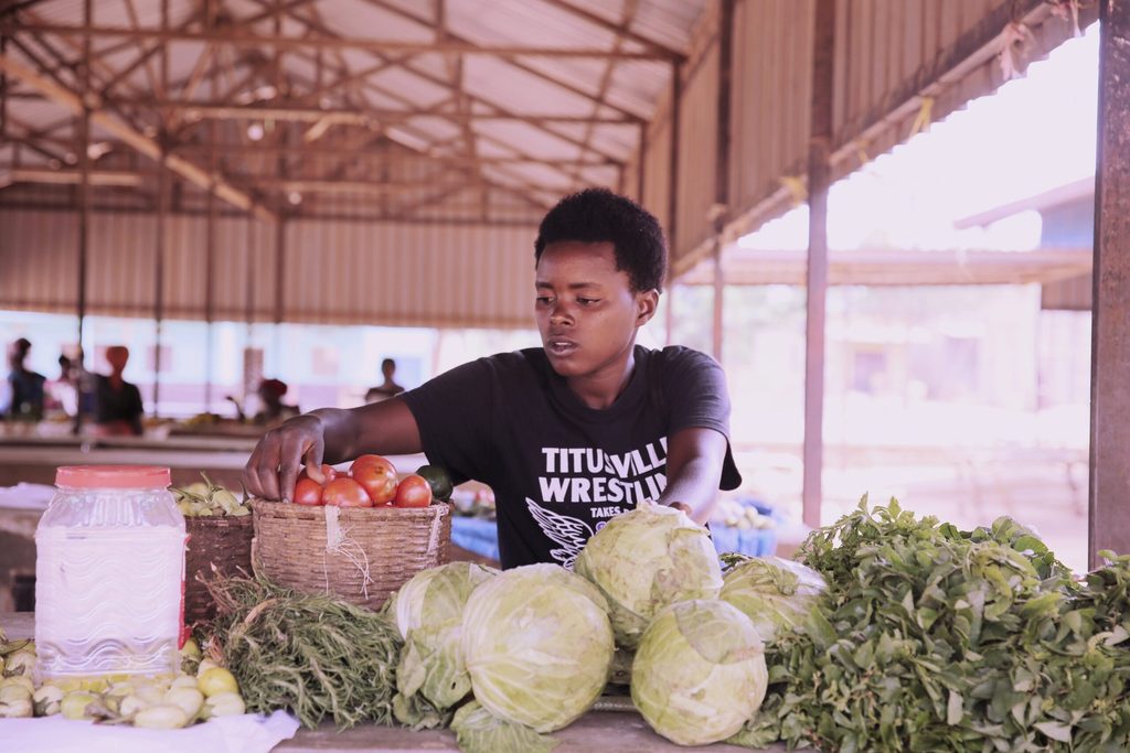 Alice selling her harvested vegetables at the market.