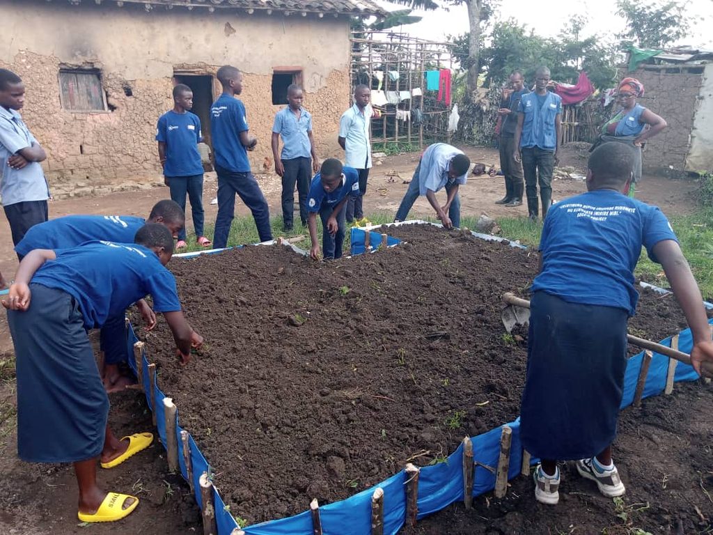 Nutrition club members tending to soil in one of the gardens. 