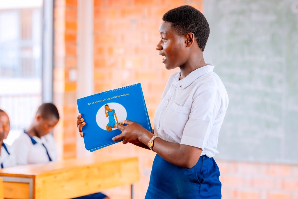 Esther, 18, educates her colleagues with a book on sexual education.