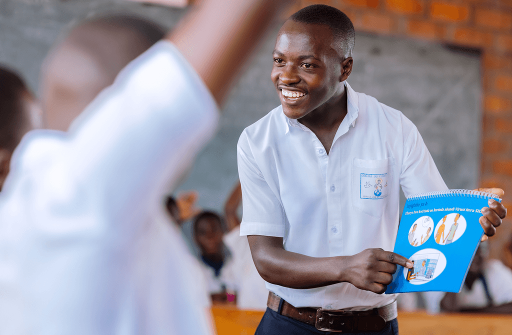 François,17, is showing other boys in the school club an information book on SRHR.