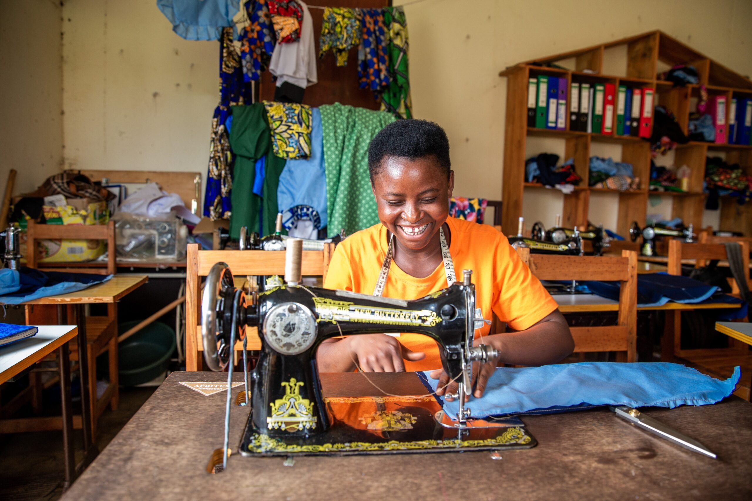 A girl from the project is working at a sewing machine.