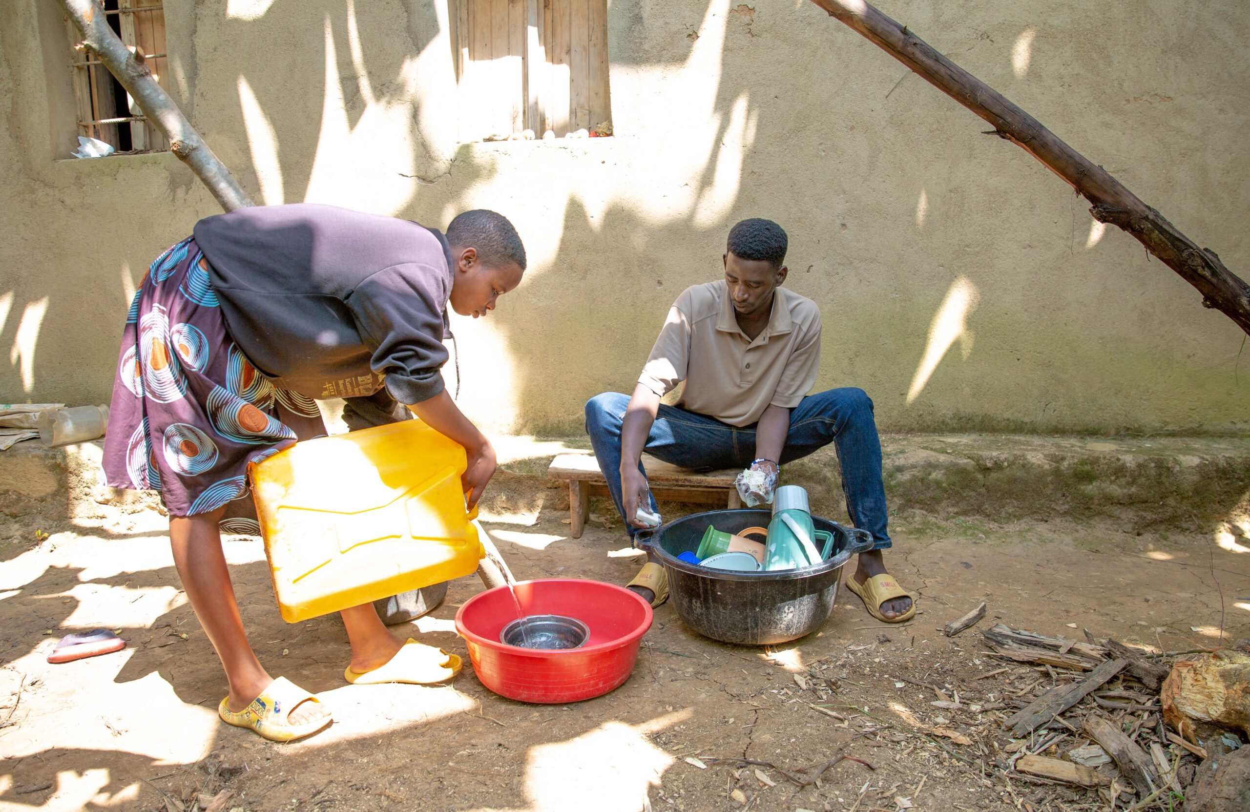 Proby and her elder brother washing dishes at home.