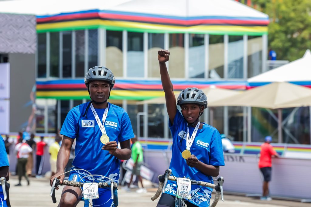 Kevine proudly displays her cycling medal.