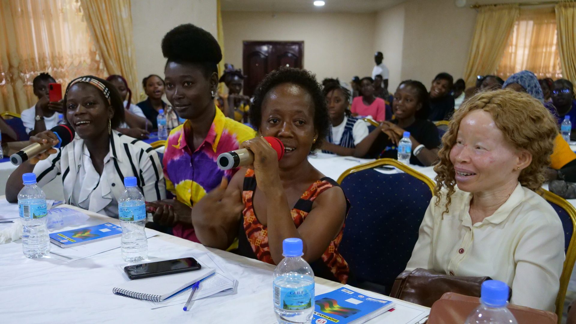 Adama (2nd right) and Jeneba (right) speaking to their peers about inclusion at the She Leads Conference