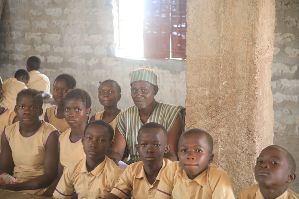 John with some of his students in a classromm in the newly-built school