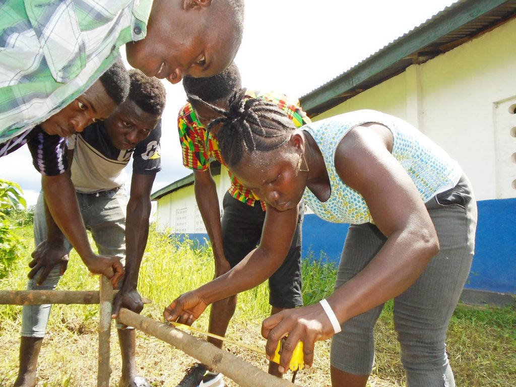 Ramatu measuring wood during her carpentry training
