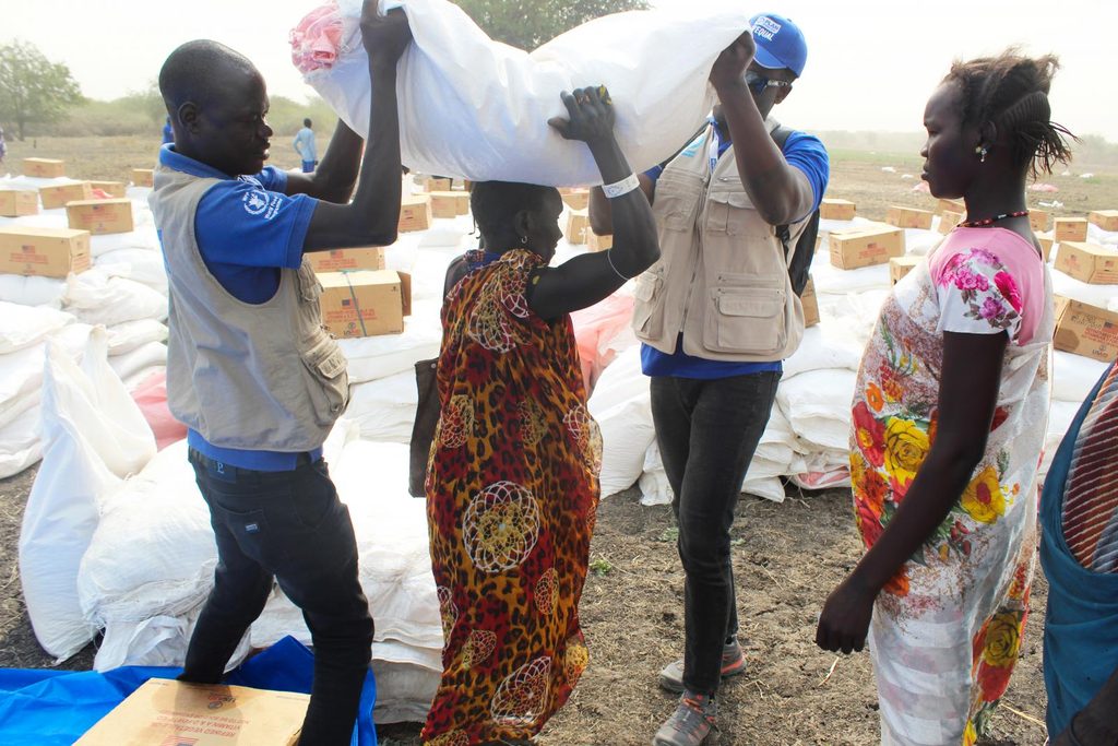 Plan International staff distribute food to vulnerable communities