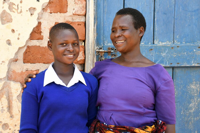 Hellen and her mother standing together and smiling.