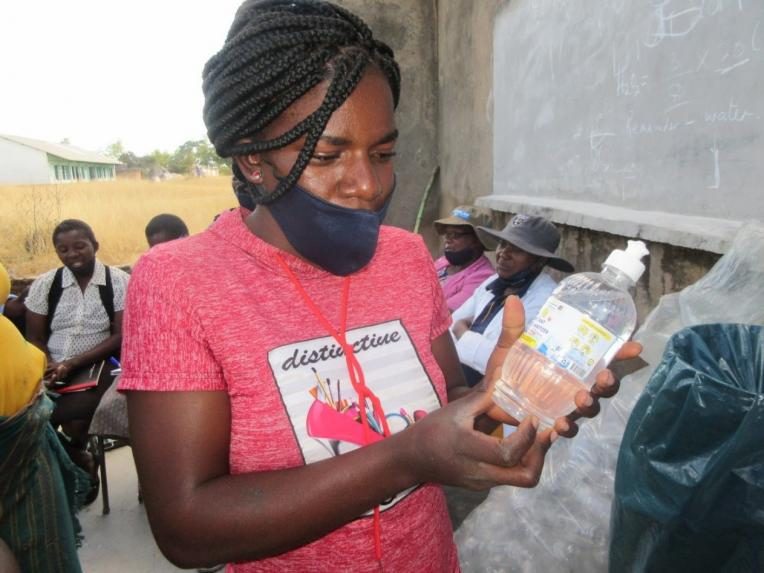  Sandra fitting labels to hand sanitiser produced during training.