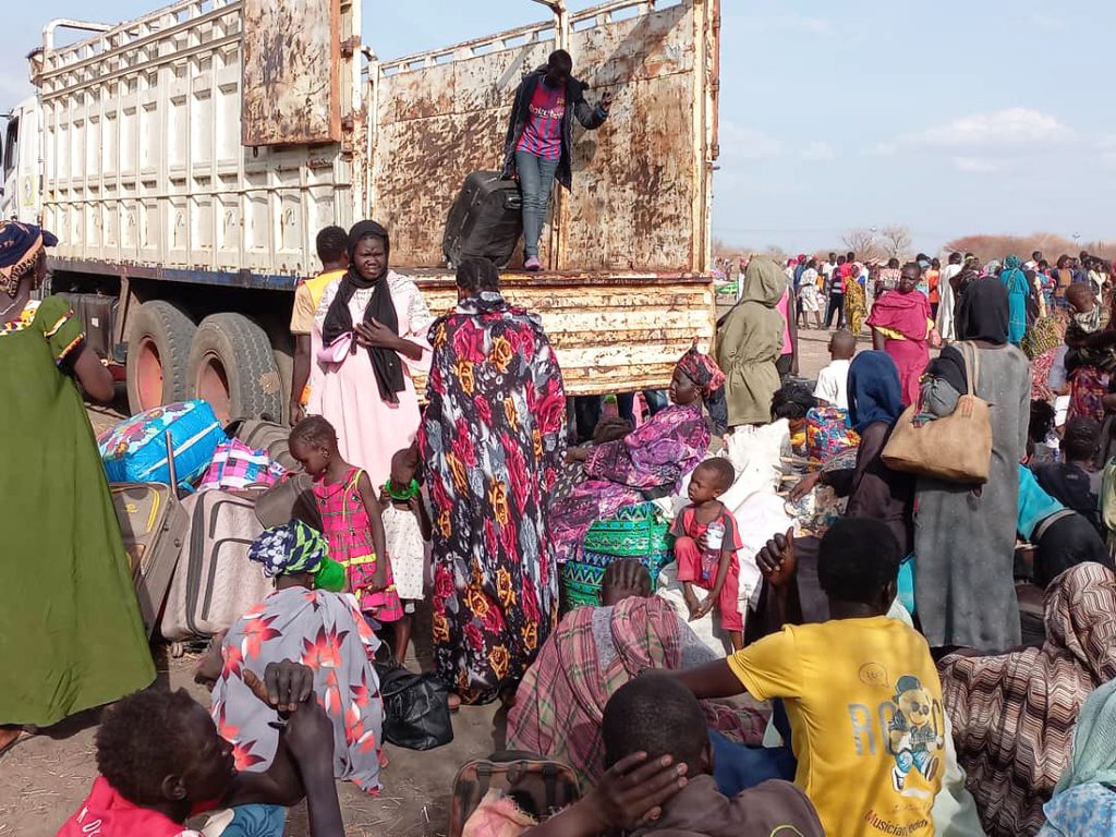 Displaced persons crossing into neighbouring country using a truck.