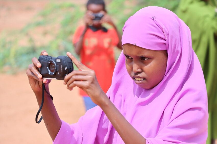 Girl takes photos for children's photography project at IDP camp
