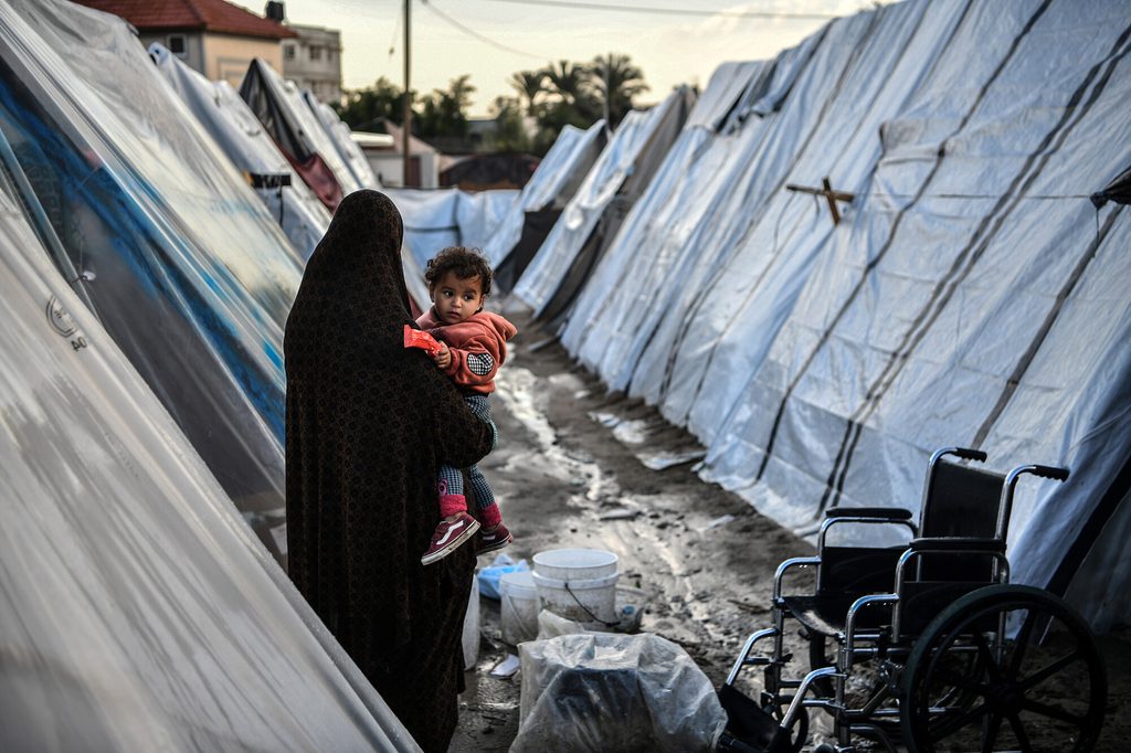 woman holding son in displacement camp