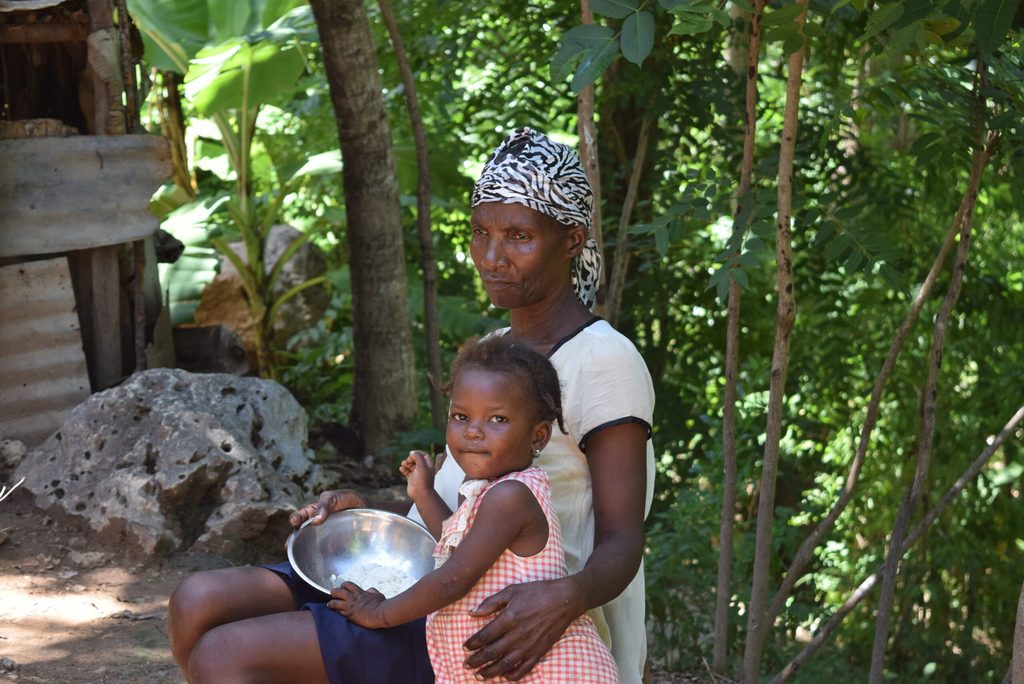 Claudette sharing a plate of rice with one of her grandchildren
