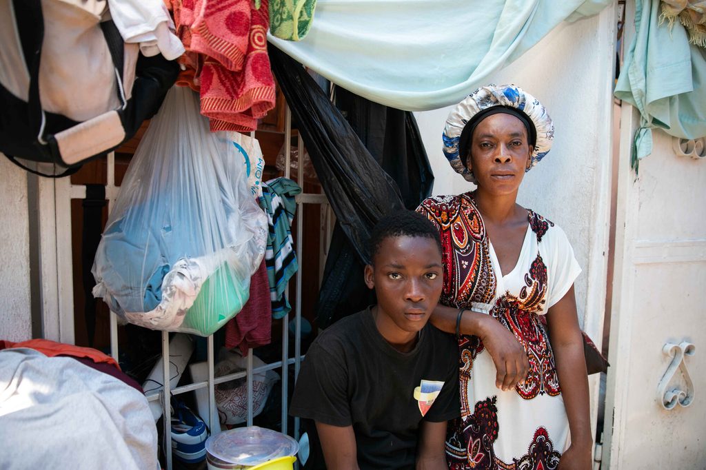 Junior*, 16, with his mother, now living in a displacement site.