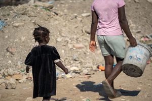 Niña haitiana junto con su madre en busca de alimentos en un mercado del departamento Sudeste de Haití.