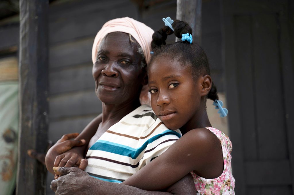 Chedeline, de 13 años, con su abuela en su casa del sudeste de Haití.