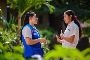 Génesis conversa con personal del proyecto de Plan International