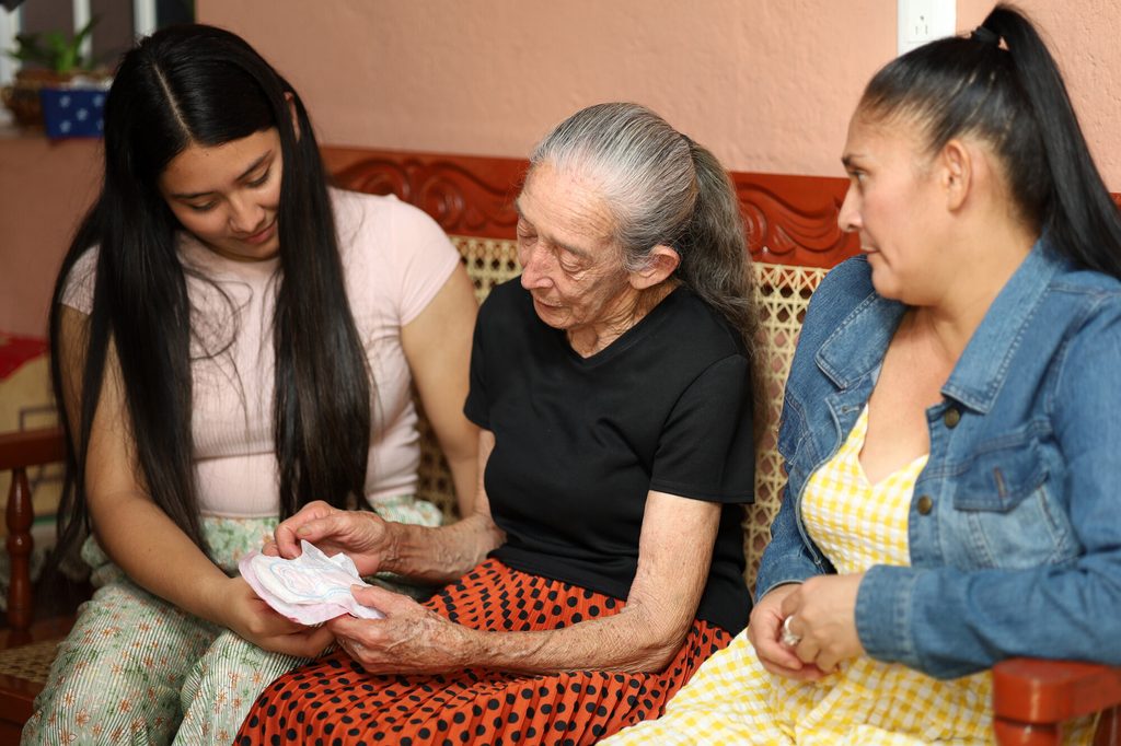Hazel, junto con su madre y su abuela conversan sobre higiene menstrual en El Salvador.